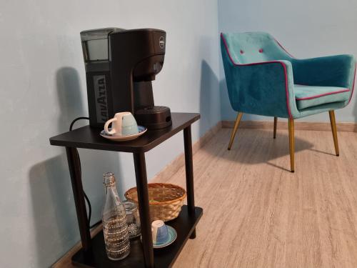 una macchinetta del caffè su un tavolo accanto a una sedia di Sweet Dream a Passignano sul Trasimeno