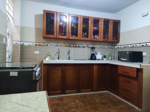 a kitchen with wooden cabinets and a sink at Apartamento Vallejo in Trujillo