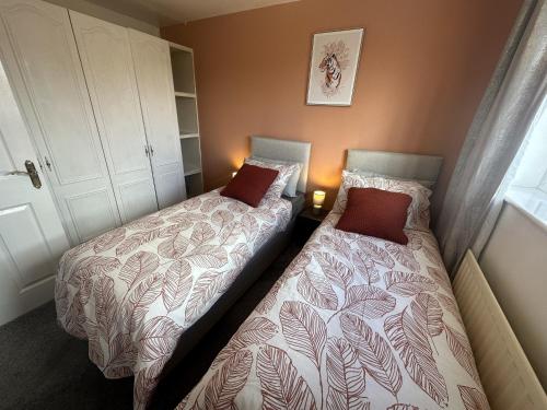 特倫特河畔斯托克的住宿－3 Bed Home for Contractors & Relocators with Parking, Garden & WiFi 30 mins to Alton Towers，卧室内两张并排的床