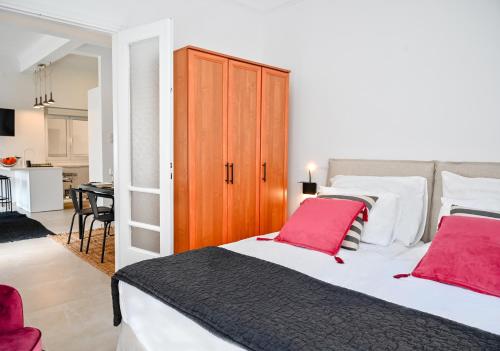1 dormitorio con 1 cama grande con almohadas rojas en Zografou luxury apartment 1 bedroom 4 pers by MPS, en Atenas