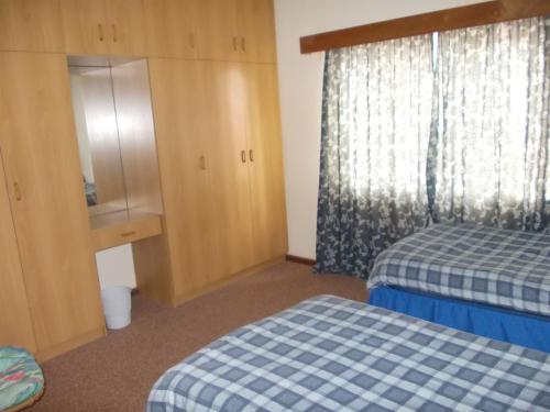 a hotel room with two beds and a window at Huis KlipdriftSelf Catering &B&B in Hentiesbaai