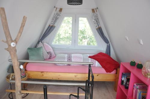 Bett in einem Zimmer mit Fenster in der Unterkunft Ferienhaus nähe Warnemünde 3 in Elmenhorst