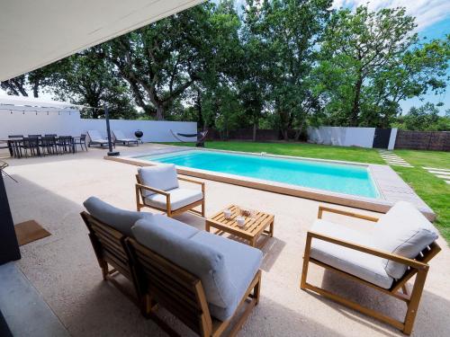 a patio with chairs and a swimming pool at Beautiful Villa close to the Seaside in Talmont