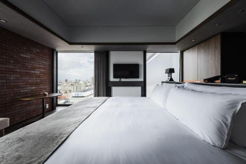 a bedroom with a large white bed with a large window at SAPPORO STREAM HOTEL in Sapporo