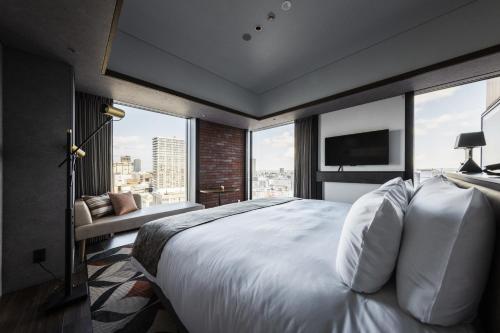 a bedroom with a large white bed with a large window at SAPPORO STREAM HOTEL in Sapporo