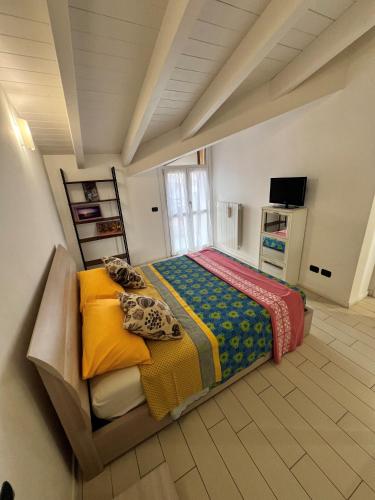a large bedroom with a bed with colorful blankets at Mansarda Polpetta in Corsico