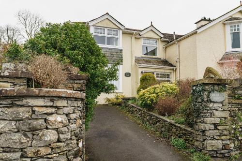 a stone wall in front of a house at Heathmere- lovely views, free parking, pet friendly in Windermere