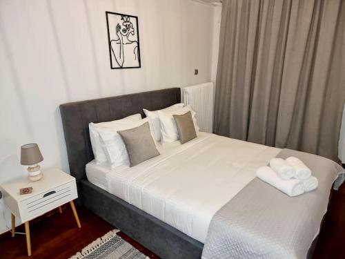 sypialnia z dużym białym łóżkiem z nocnym stolikiem w obiekcie 53 Central Luxury Apartment Kalamaria Thessaloniki w Salonikach