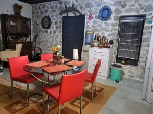 a dining room with a table and red chairs at Canerbey Çiftlik in Ovacık