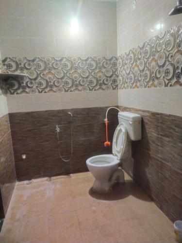a bathroom with a toilet and a shower at JR A/c Rooms in Tiruvannāmalai