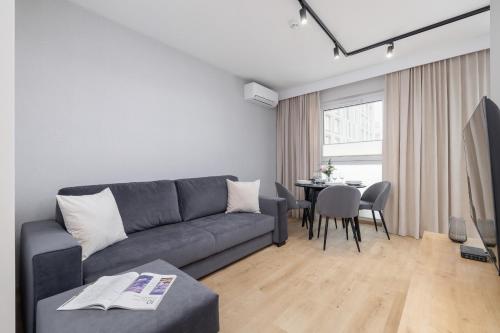 a living room with a couch and a table at Bright Apartment in Kraków with Garden, Air Conditioning, Parking and Desk by Renters Prestige in Kraków