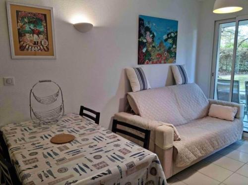 un salon avec un canapé et une table dans l'établissement Appartement avec piscine - 6494, à Soulac-sur-Mer