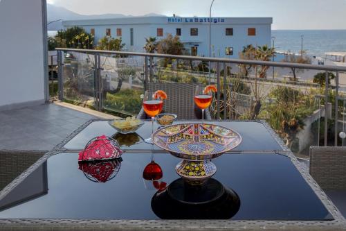 una mesa con copas de vino en la parte superior de un balcón en Terrazza sul Golfo, en Alcamo