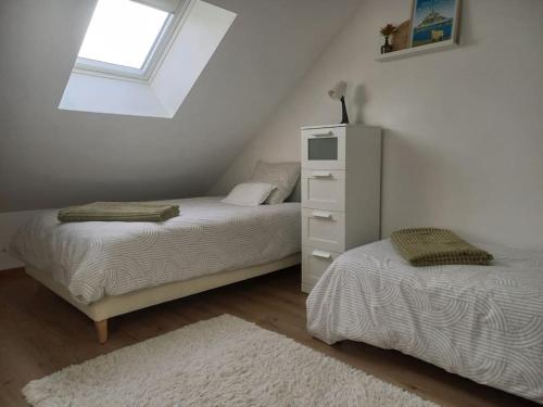 1 dormitorio con 2 camas y vestidor blanco en Gîte de la vallerie - Entre Seine et Mer, en Auzebosc