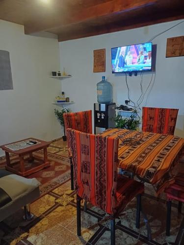 a living room with a table and chairs and a tv at Estrella Ancestral 1 in San Pedro de Atacama