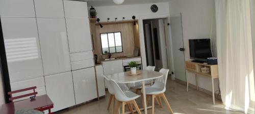 une petite cuisine avec une table et des chaises dans une pièce dans l'établissement Love nest with 2 balconies offering sea views, à Toulon