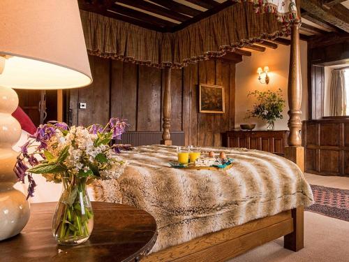 - une chambre avec un lit et un vase de fleurs sur une table dans l'établissement 5 Bed in Betws-y-Coed 55987, à Pentrefoelas