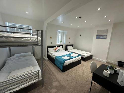 a bedroom with two bunk beds and a desk at Olive Lodge Blackpool in Blackpool