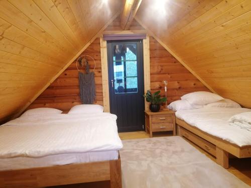 a bedroom with two beds in a wooden cabin at Tirtsu puhkemaja 