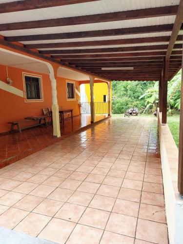 an outside view of a house with a patio at Maison charmante à Pointe Noire, vue montagne, jardin privé in Pointe-Noire