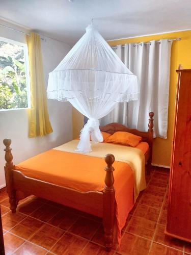 a bedroom with a bed with a canopy at Maison de 3 chambres avec jardin amenage et wifi a Pointe Noire a 1 km de la plage in Pointe-Noire