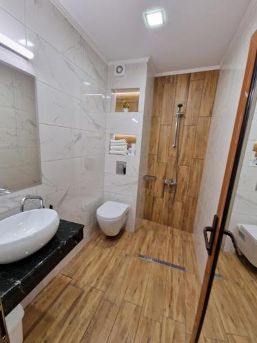 a bathroom with a shower and a toilet and a sink at Lucky Hotel in Veliko Tŭrnovo