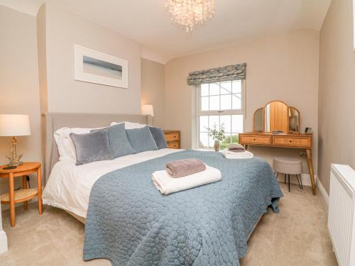 a bedroom with a bed with a blue blanket at Applestow in Bideford