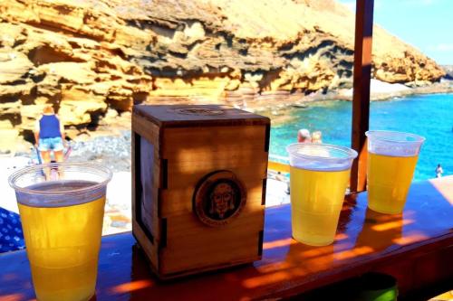 a table with two glasses of beer and a radio at Villa La Flor de Anaga in Las Lagunas