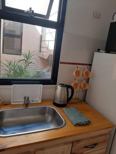 a kitchen counter with a sink and a window at Vento Apart in Chivilcoy