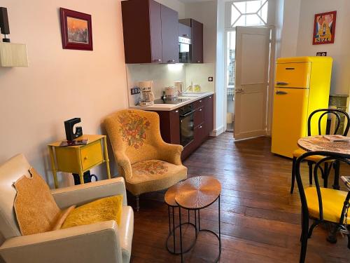 une cuisine avec des chaises et une table dans une pièce dans l'établissement Meublé de tourisme Art§Vintage, à Oloron-Sainte-Marie