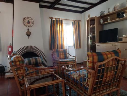 a living room with chairs and a fireplace at Buztinzuri Da Ria in Torreira