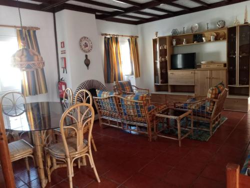 a living room with chairs and a table and a television at Buztinzuri Da Ria in Torreira