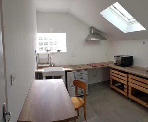 une cuisine avec une table, un évier et une fenêtre dans l'établissement Détour en baie de somme, au Crotoy