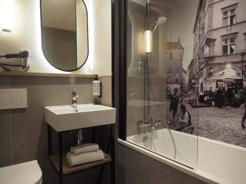 a bathroom with a sink and a mirror and a tub at Campanile Lyon Centre Part-Dieu in Lyon