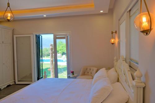 1 dormitorio con cama blanca y ventana grande en Vahide Homes, en Doger Koyu