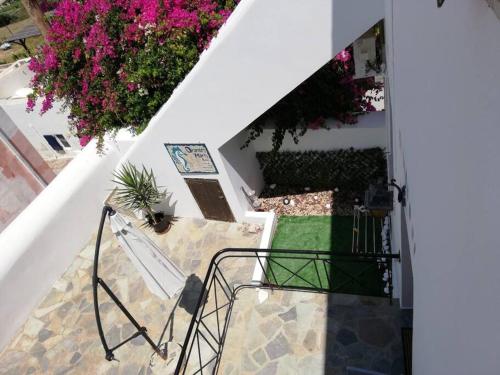 an ascending stairway with pink flowers and plants at Οrantes Maris Family And Groups in Katapola