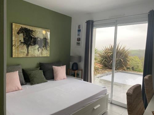 une chambre avec un lit et une grande fenêtre dans l'établissement Entre mer et montagne AMA LUR, à Hasparren