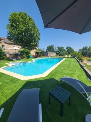 una piscina con un banco en un patio en Les Dépendances du Château, en Noailles