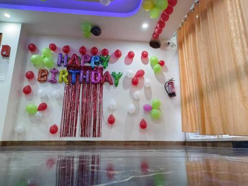 uma parede com balões e um sinal de feliz aniversário em OYO Hotel Oyo Sky Hills Near Chaudhary Charan Singh International Airport em Bijnaur