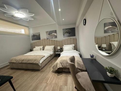 een slaapkamer met 2 bedden en een spiegel bij Hotel Vila Tirana in Tirana