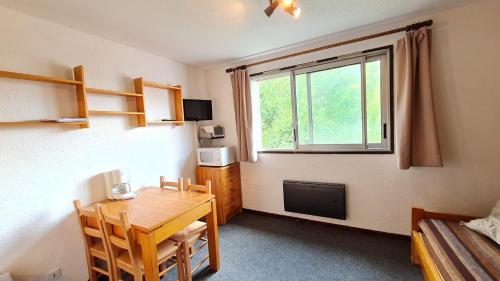 Cette petite chambre dispose d'une table et d'une fenêtre. dans l'établissement Kandahar - 167 - Studio - 2 pers, à Les Deux Alpes