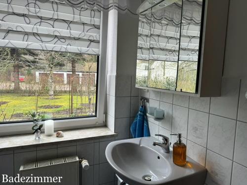 a bathroom with a sink and two windows at Ferienwohnung Schröder in Putbus