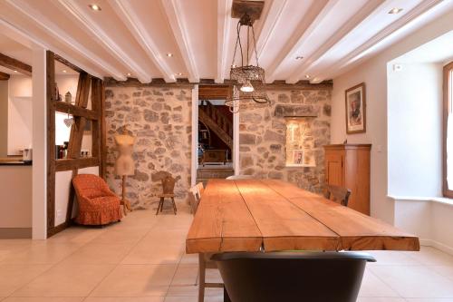 une salle à manger avec une table en bois et des murs en pierre dans l'établissement Belle Maison Alsacienne de 1610, à Gueberschwihr