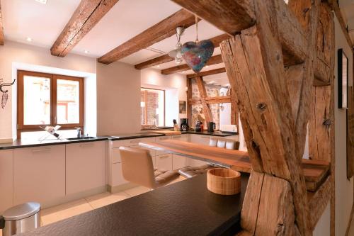cocina con mesa y pared de madera en Belle Maison Alsacienne de 1610, en Gueberschwihr