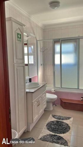 a bathroom with a sink and a toilet and a shower at Casa do Ilhéu in Vila Franca do Campo
