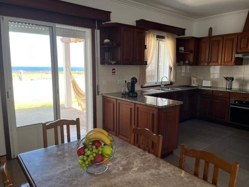 a kitchen with a table with a bowl of fruit on it at Casa do Ilhéu in Vila Franca do Campo