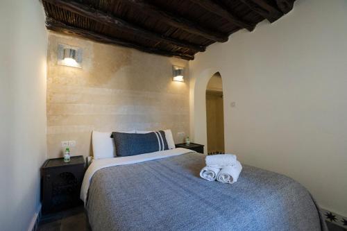 a bedroom with a large bed with towels on it at Riad Dar Nor in Essaouira