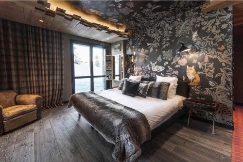 una camera con un grande letto in una stanza con carta da parati di Chalet sisimut a Courchevel