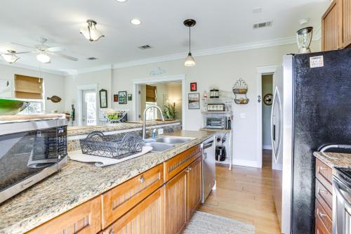 a large kitchen with wooden cabinets and stainless steel appliances at Lovely Carrabelle Home with Lake Views and Pool Access in Carrabelle