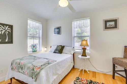 a bedroom with a bed and two windows at Lovely Carrabelle Home with Lake Views and Pool Access in Carrabelle